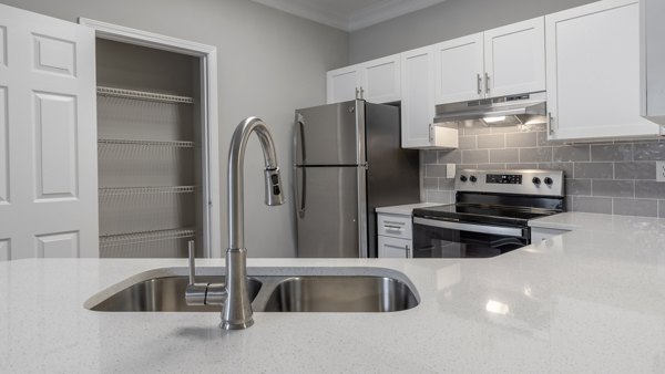 Modern kitchen with stainless steel appliances and granite countertops in The Slate Apartments