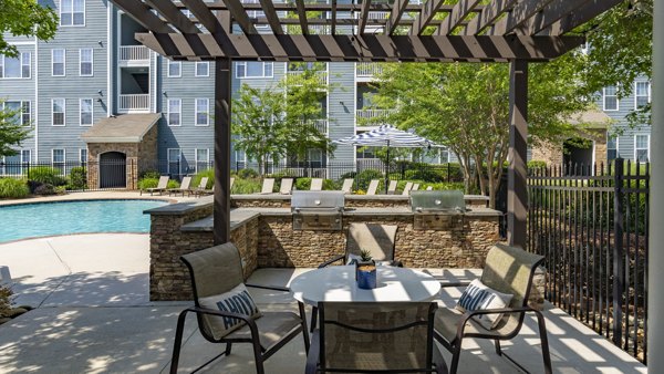 Outdoor grill area with seating at The Slate Apartments, offering a perfect spot for barbecues and social gatherings