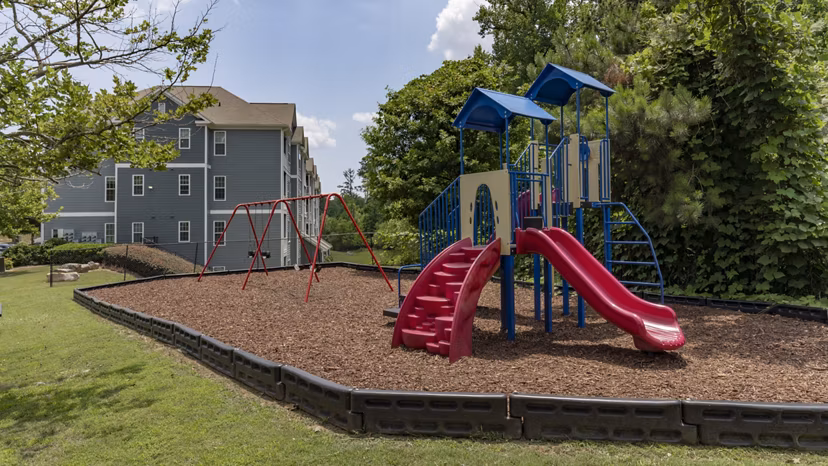 Children's playground with colorful slides and swings at The Slate Apartments, perfect for family living in a vibrant community