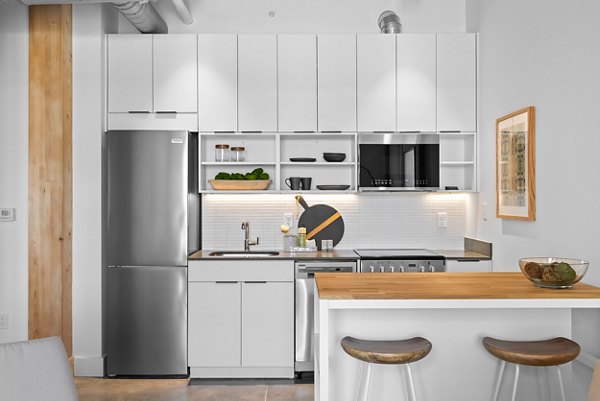 Modern kitchen featuring granite countertops and stainless steel appliances at Ann Street Lofts Apartments