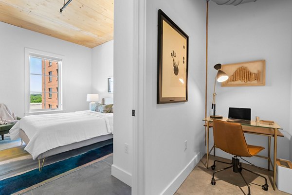 Modern living room with sleek furniture and large windows at Ann Street Lofts Apartments