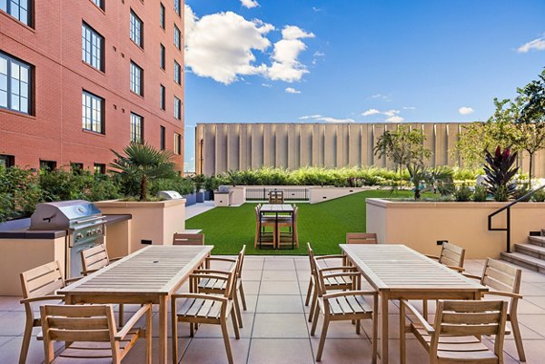 Cozy outdoor patio space at Ann Street Lofts Apartments featuring seating and lush greenery