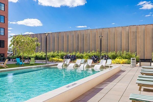 Large outdoor pool surrounded by lush landscaping at Ann Street Lofts Apartments