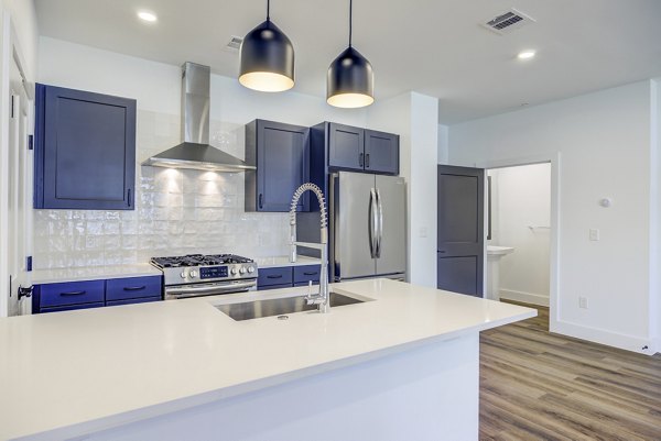 Modern kitchen with stainless steel appliances at Escalon Townhomes Apartments, offering luxury living in a contemporary setting