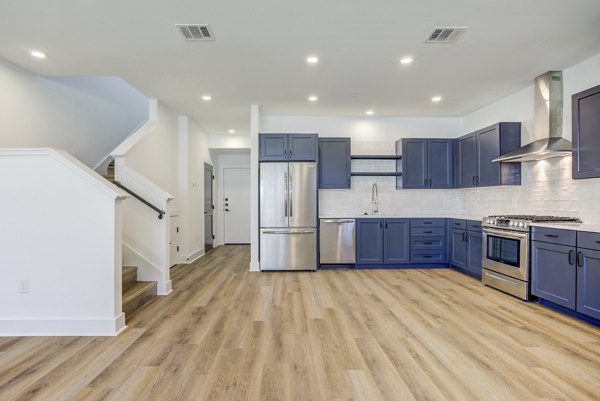 Modern kitchen with granite countertops and stainless steel appliances at Escalon Townhomes Apartments