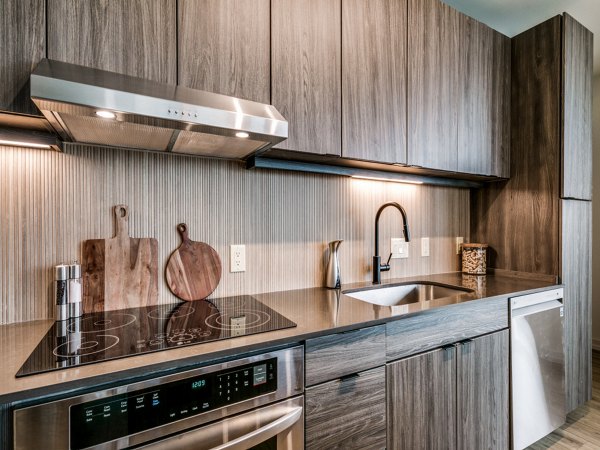 Modern kitchen with sleek appliances and granite countertops at 3700M Apartments, a luxury Greystar property
