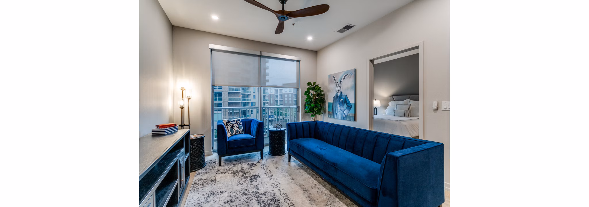 Modern living room with stylish decor at 3700M Apartments: Luxury space featuring a sofa and large windows in urban setting