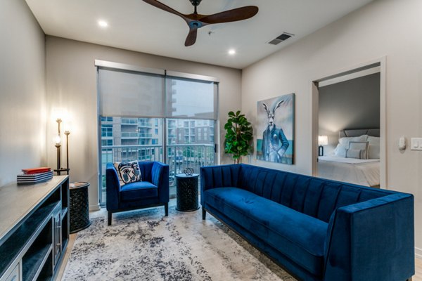 Modern living room with stylish decor at 3700M Apartments: Luxury space featuring a sofa and large windows in urban setting