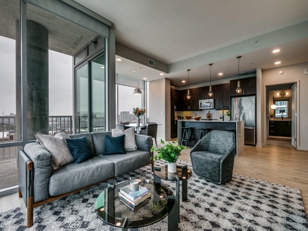 Spacious living room with modern decor and large windows at 3700M Apartments