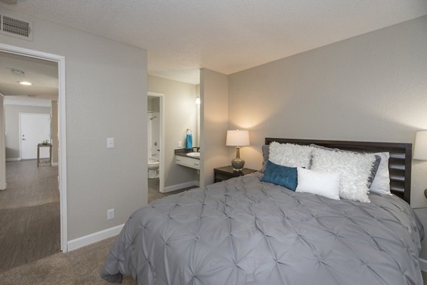 The Hills Apartments: Modern bedroom with elegant decor and ample natural light