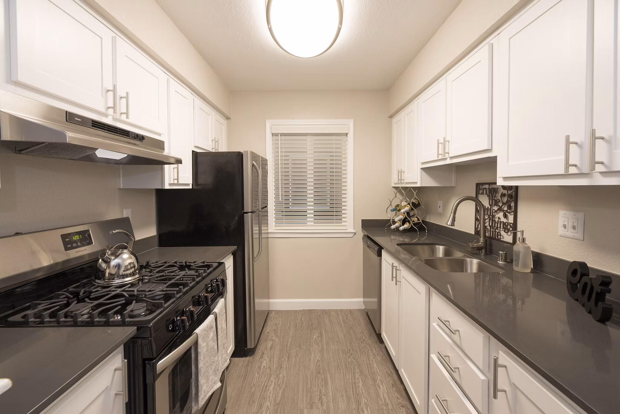 Modern kitchen featuring stainless steel appliances and granite countertops at The Hills Apartments