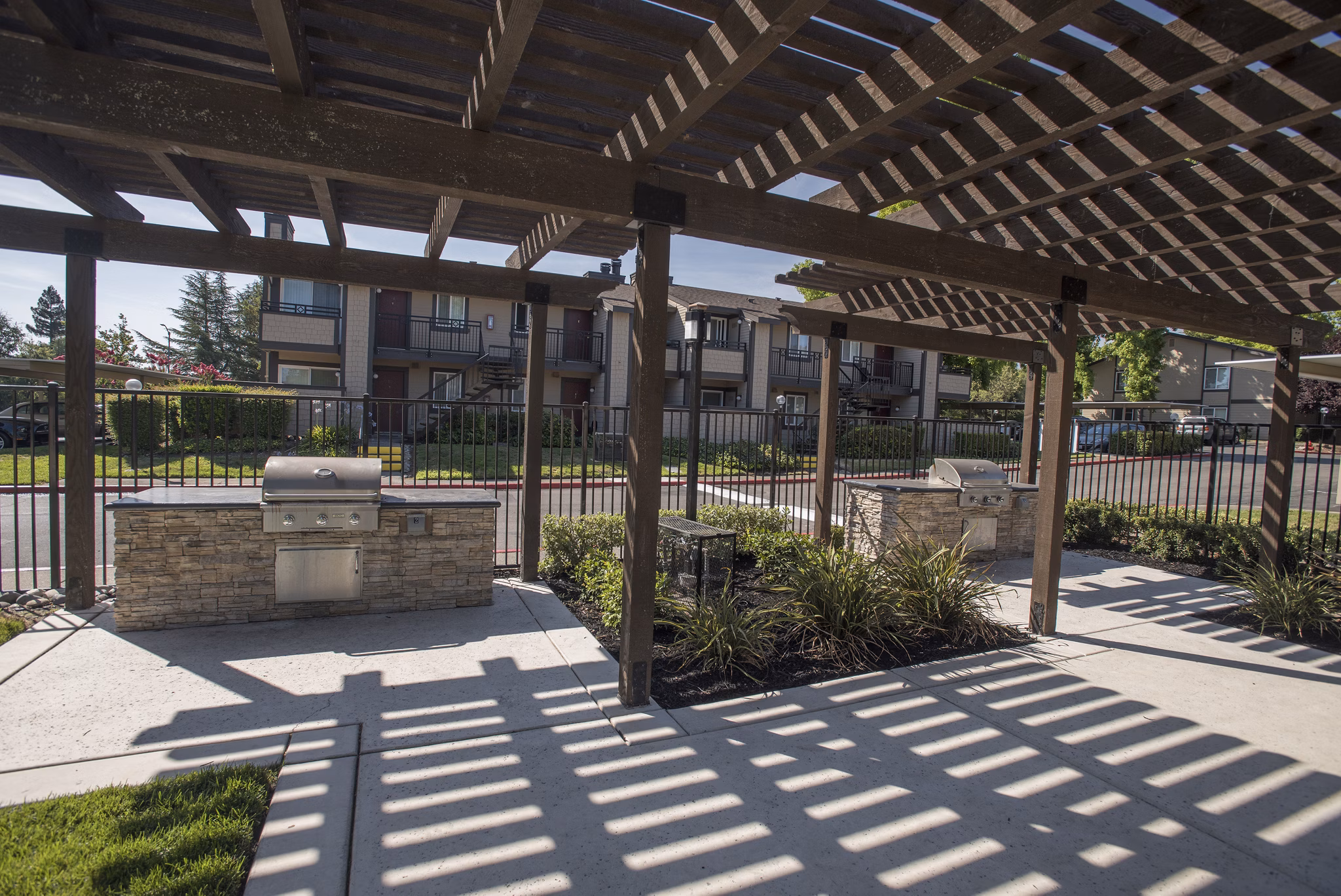 Outdoor grill area at The Hills Apartments featuring modern BBQ facilities and picnic seating