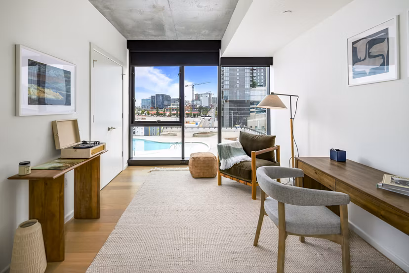 Bedroom/home office with modern decor and city views at 1111 Church Apartments