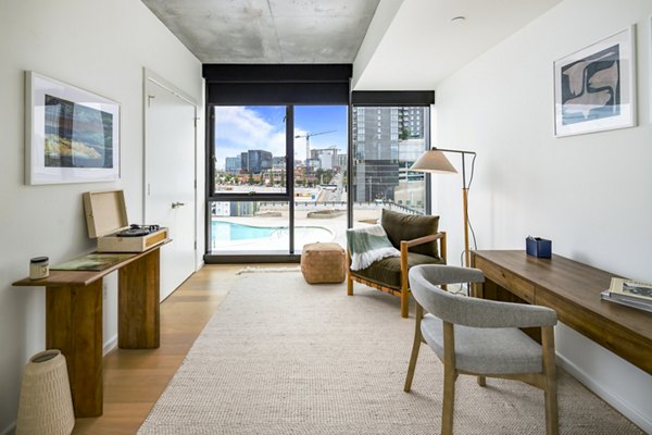 Bedroom/home office with modern decor and city views at 1111 Church Apartments