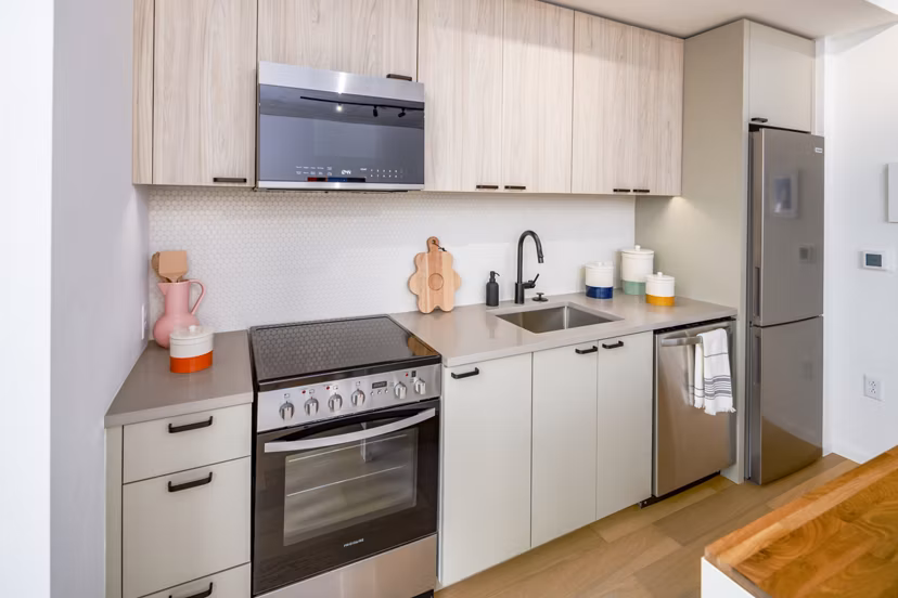 Modern kitchen with stainless steel appliances and granite countertops in 1111 Church Apartments