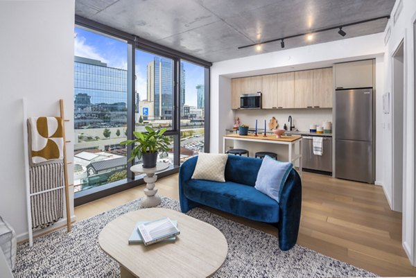 Modern living room with large windows and stylish decor at 1111 Church Apartments