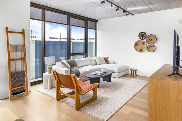 Elegant living room with contemporary decor at 1111 Church Apartments, a Greystar luxury community, featuring natural light and modern furnishings