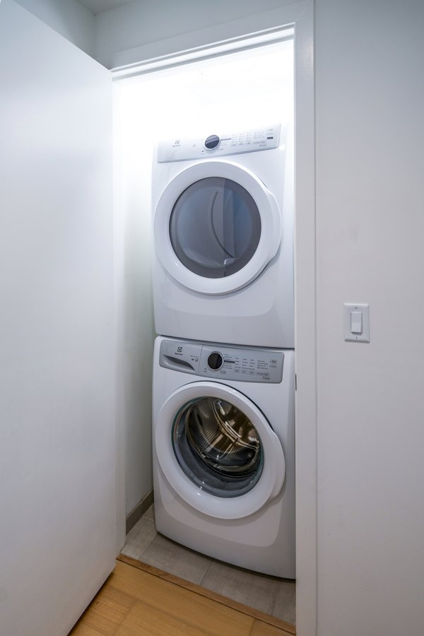Laundry room with modern washers and dryers at 1111 Church Apartments, a Greystar luxury property