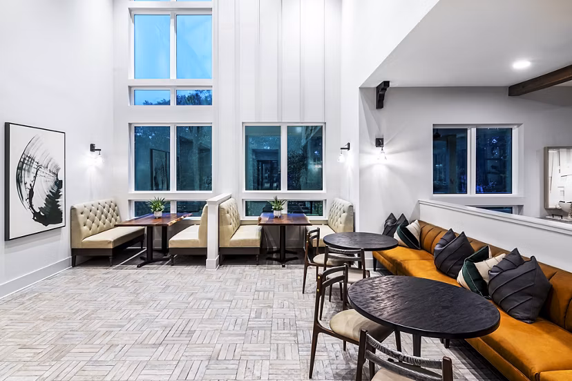Stylish clubhouse with cozy seating and large windows at Elan Sweetwater Creek Apartments
