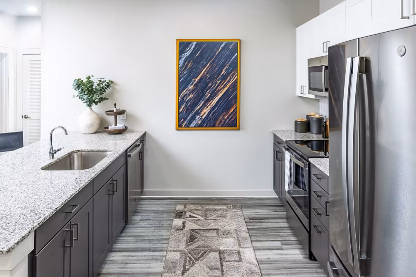 Modern kitchen with stainless steel appliances and island in Elan Sweetwater Creek Apartments