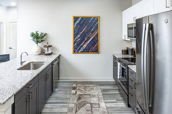 Modern kitchen with stainless steel appliances and island in Elan Sweetwater Creek Apartments