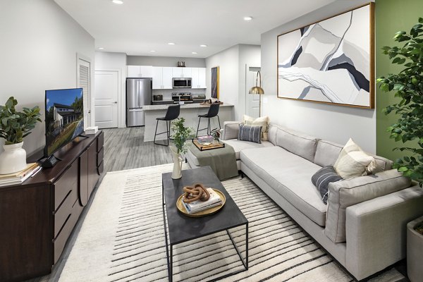 Modern living room with plush seating and large windows at Elan Sweetwater Creek Apartments offering luxury and comfort in tranquil surroundings