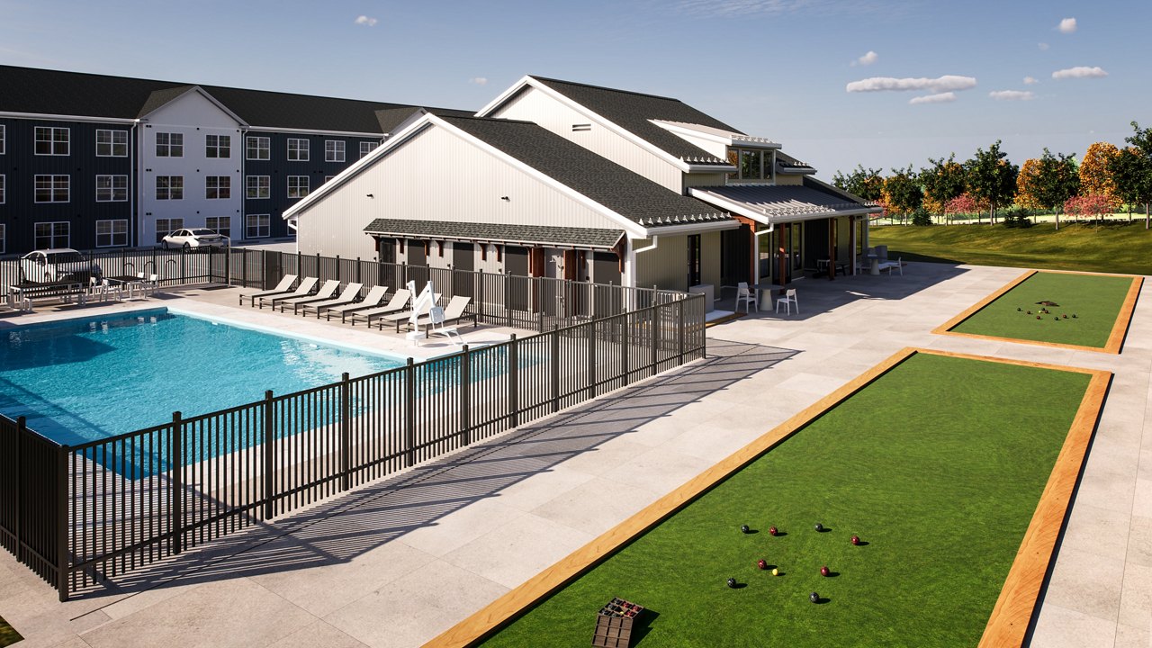 Apartment complex with an outdoor swimming pool and bocce ball courts, showcasing recreational amenities for residents.