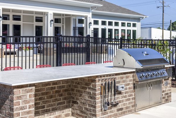 Grill and seating area on the patio at Prose New Hope Apartments with modern design and lush greenery