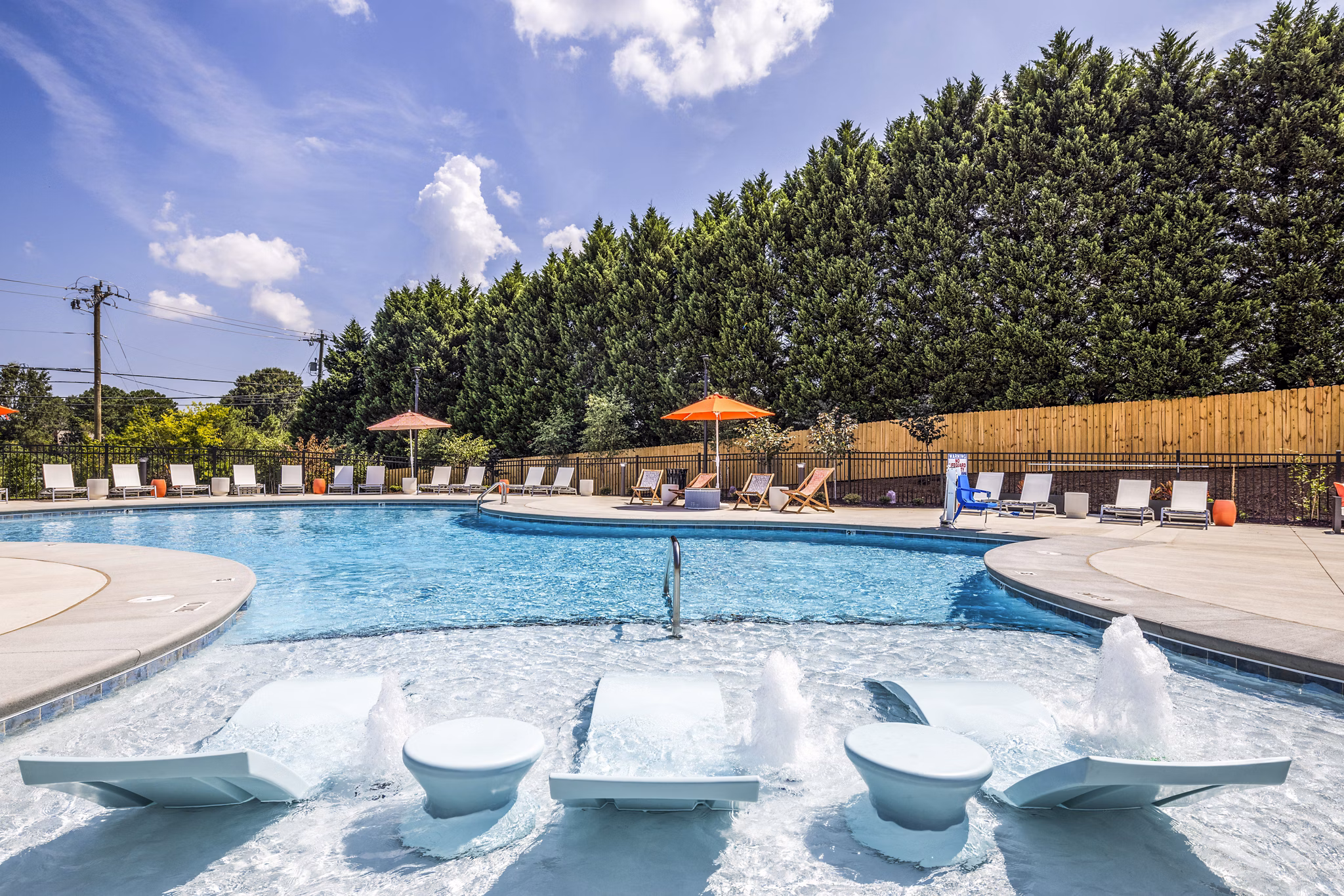 Elegant poolside retreat at Prose New Hope Apartments with lounge chairs and lush landscaping