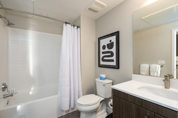 Bathroom with marble countertops and a glass shower in Prado Apartments, luxury living by Greystar
