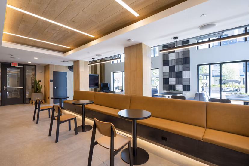 Clubhouse at Prado Apartments: Modern luxury facility with comfortable seating and fireplace in exclusive Greystar community