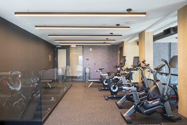State-of-the-art yoga/spin studio at Prado Apartments with modern equipment and ample space for fitness enthusiasts