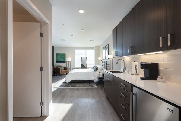 Modern kitchen with sleek appliances and island at Prado Apartments, offering luxury living spaces near city center