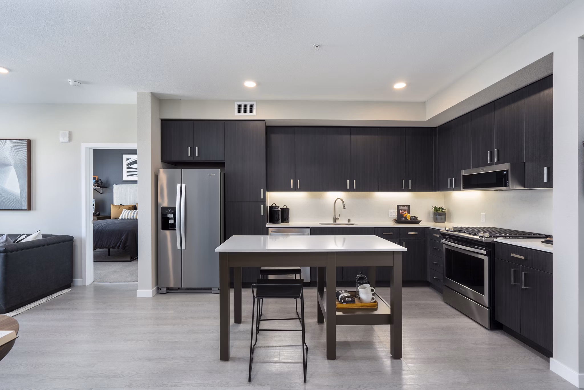 Modern kitchen with stainless steel appliances and marble countertops at Prado Apartments