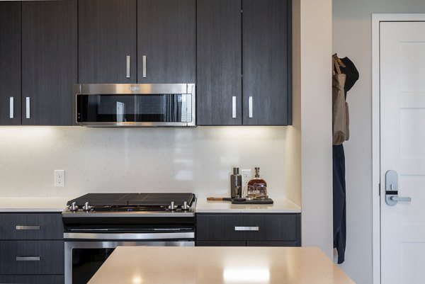 Modern kitchen with sleek countertops and stainless steel appliances in Prado Apartments