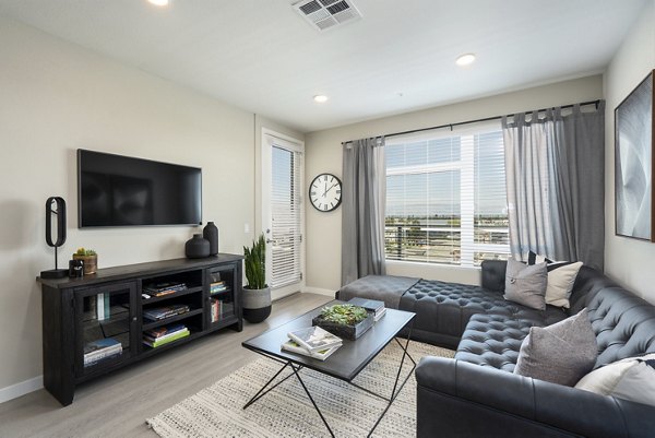 Cozy living room with contemporary decor and ample natural light at Prado Apartments