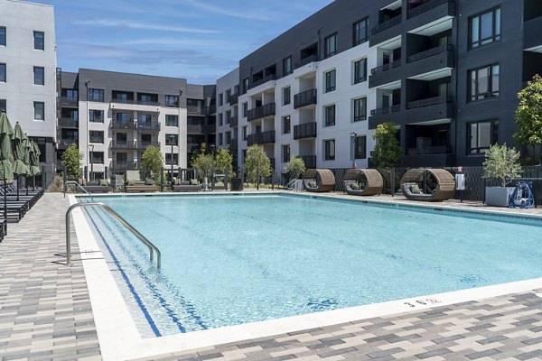 Resort-style pool surrounded by palm trees at Prado Apartments