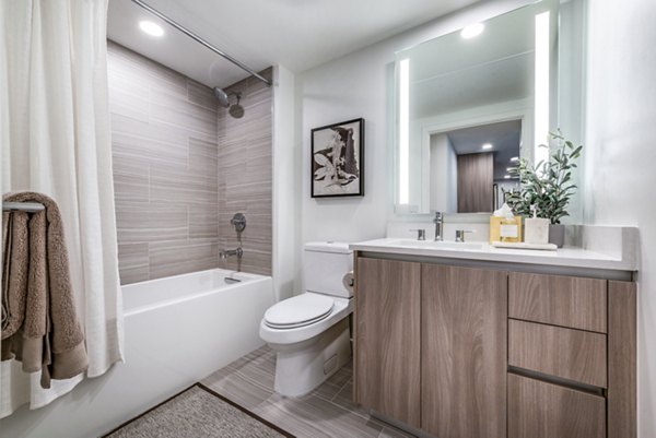 Modern bathroom featuring a stylish bathtub, shower, and elegant decor in luxury apartments