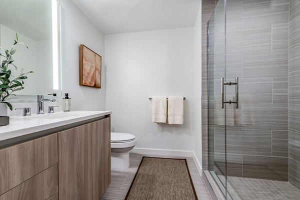 Modern bathroom with glass shower and elegant vanity in luxury apartment Features towels and small plant for a stylish touch