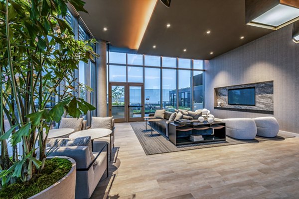Modern living room featuring large windows and stylish seating area in luxury apartments