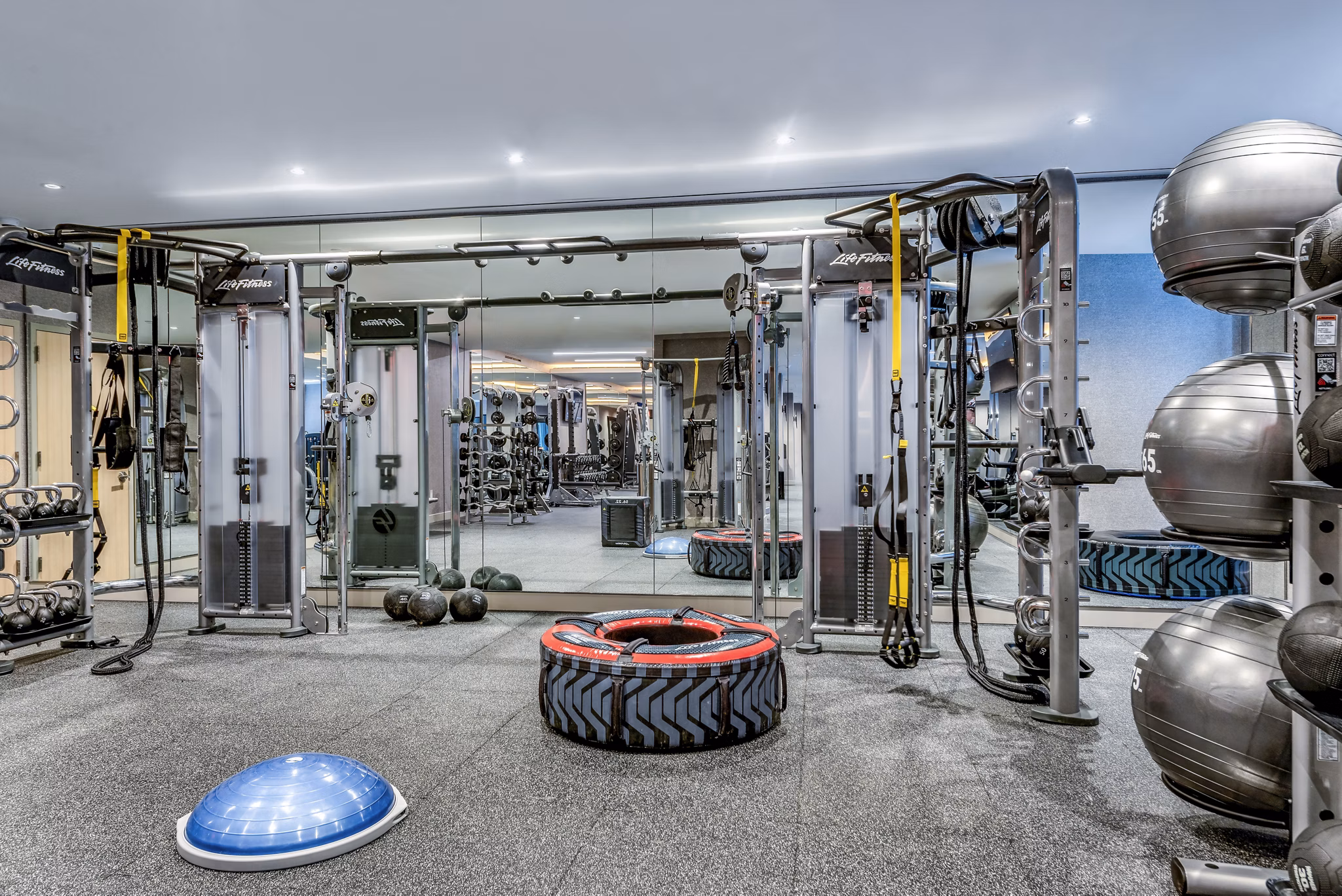 Well-equipped fitness center with weight machines and exercise balls in luxury apartment community