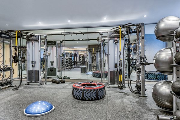 Well-equipped fitness center with weight machines and exercise balls in luxury apartment community
