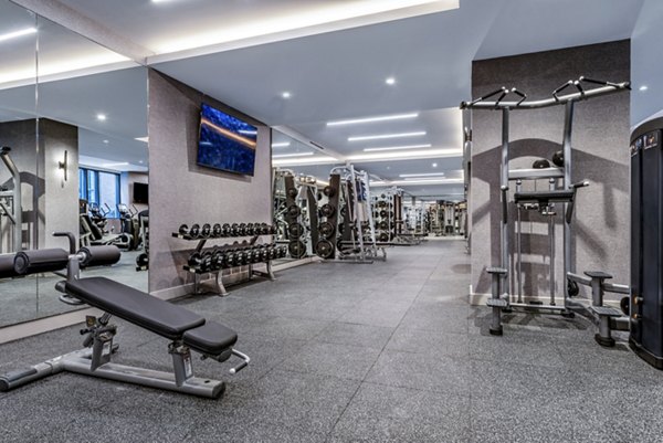 State-of-the-art fitness center with weights and machines in luxury apartments