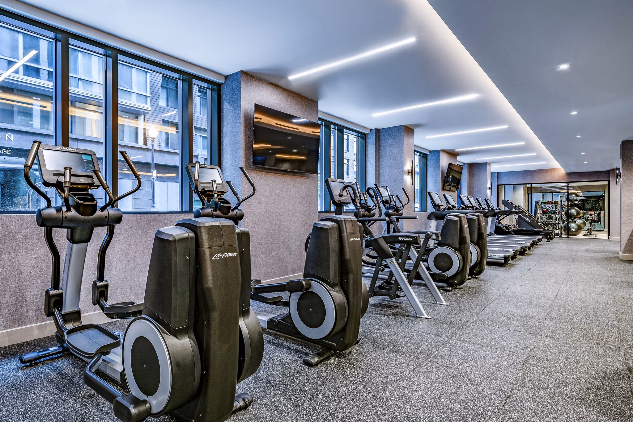 Modern fitness center with elliptical machines and treadmills at luxury apartments