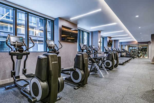 Modern fitness center with elliptical machines and treadmills at luxury apartments