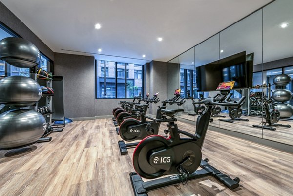 Fitness room with stationary bikes and exercise balls in luxury apartments