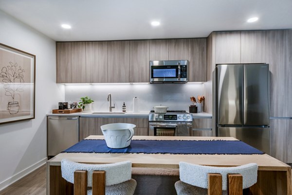 Modern kitchen with wooden cabinets and stainless steel appliances in luxury apartments
