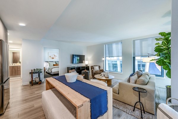 Modern living room and kitchen with stainless steel appliances and large windows in luxury apartment