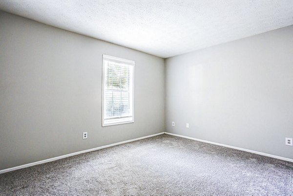 Cozy bedroom with ample natural light at Hairston Woods Apartments