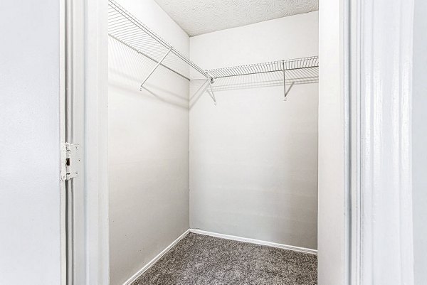 Walk-in closet with ample shelving in Hairston Woods Apartments' bedroom, offering organized storage lifestyle in luxurious urban setting